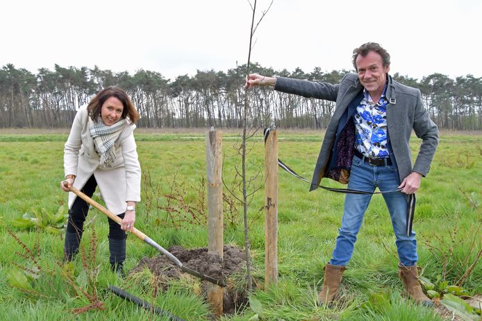 Gedeputeerde Anita Pijpelink en wethouder Gino Depauw planten een boom op een nieuw verworven akker in de Clingepolder.