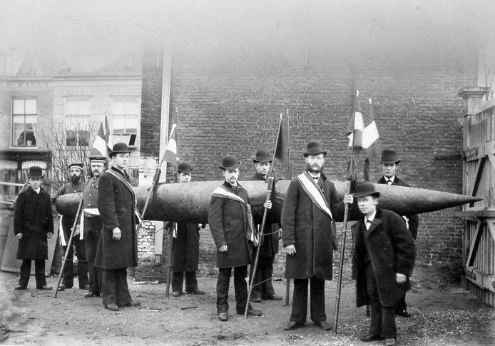 De super sigaar van Drughorn: 5,30 meter lang en 40 kilo zwaar. De sigaar moest gedragen worden door acht mannen. Vooraan en achteraan staan vermoedelijk vader en zoon Drughorn, de directeuren van de fabriek.