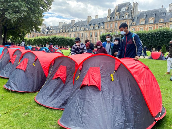 Des migrants et des militants d'ONG installent un campement composé de tentes pour attirer l'attention sur les conditions de vie des migrants et demander un hébergement, sur la Place des Vosges à Paris.