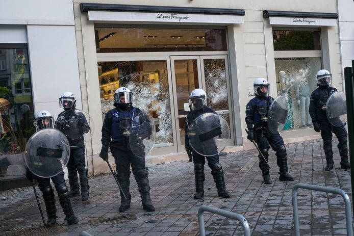 De Belgische oproerpolitie bewaakt winkels aan de Waterloolaan in Brussel waarvan de ruiten werden ingegooid.