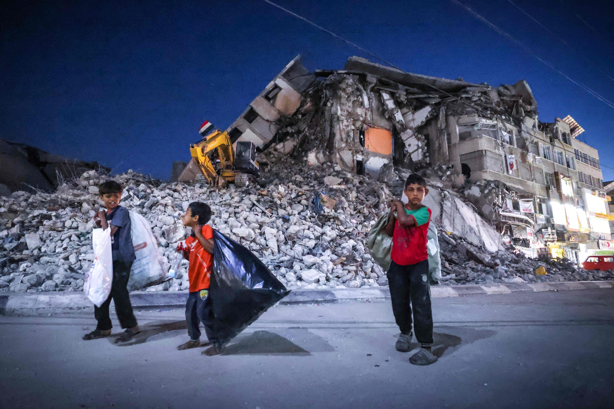 Palestijnse jongens lopen langs een door Israël verwoest gebouw in Gaza Stad.