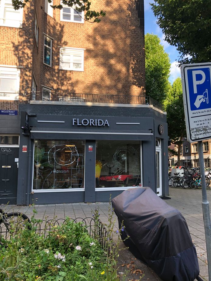 De ingegooide ramen van snackbar Florida aan de kant van de Van Woustraat...