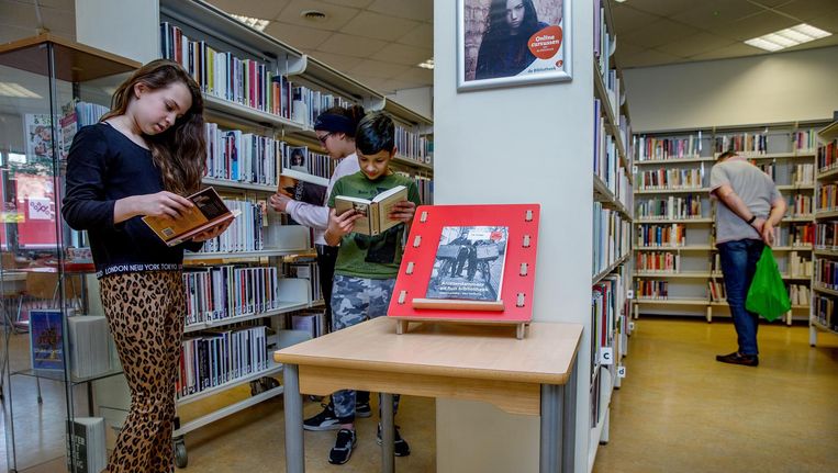 Hoge kasten vol boeken onder een systeemplafond: de verouderde bibliotheek Calandlaan gaat dicht. Beeld Jean-Pierre Jans