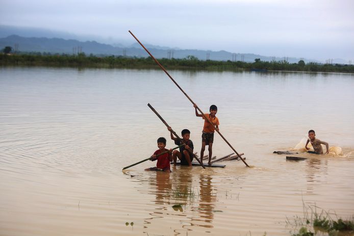 Kinderen op een geïmproviseerd vlot van bamboe in de staat Rakhine in Myanmar, nadat de regio werd getroffen door hevige moessonregens.