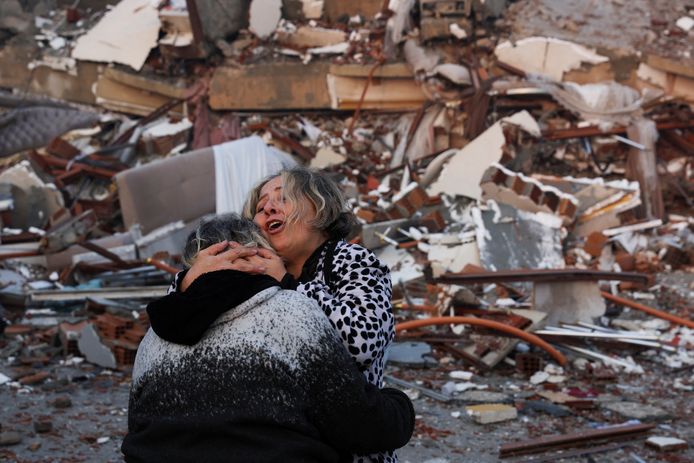 Een vrouw huilt bij het puin van een ingestort gebouw in Hatay in Turkije.