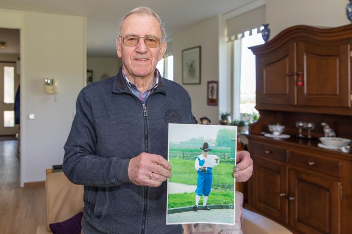 Gatze de Moed in zijn woonkamer in Maartensdijk met een foto waarop hij te zien is als stadsomroeper.