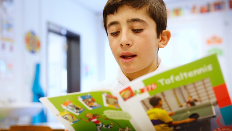 Een Syrische jongen leert Nederlands op het AZC in Leersum. Beeld anp