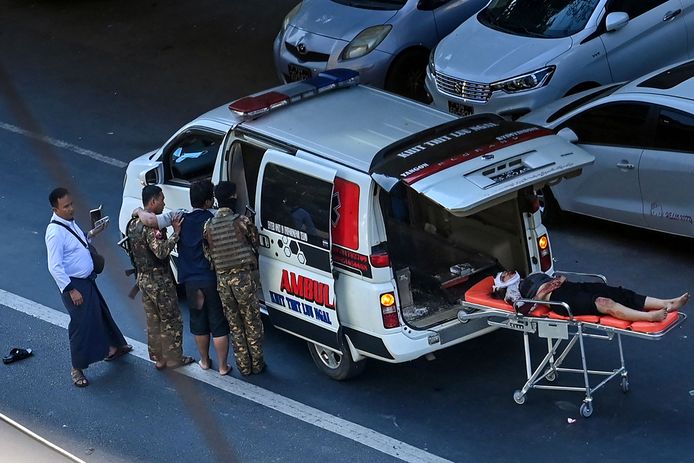 Een journalist, die op het protest tegen de militaire coup was om er verslag uit te brengen, krijgt medische ondersteuning. Een gewonde ligt op een brancard.