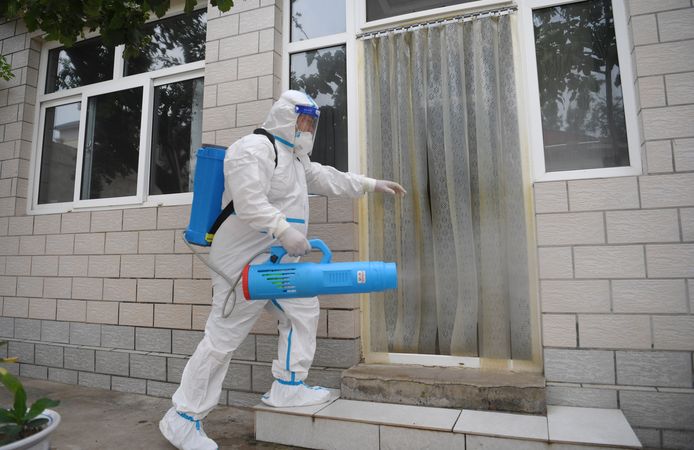 Een gezondheidsmedewerker desinfecteert een gebouw in China. Foto ter illustratie.