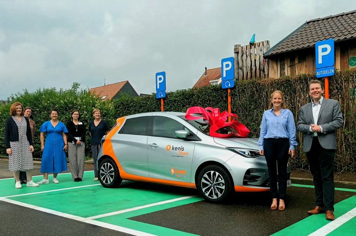 Vooraan staat Burgemeester Lieven Janssens (r.) samen met een medewerkster van Kenis Auto's bij één van de twee elektrische deelwagens in Vorselaar