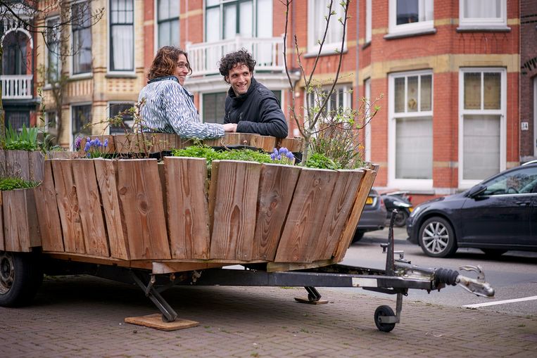 Walter Dresscher van De Natuurlijke Stad in gesprek met Sandra Nap in de DebatMobiel, een mobiele plek met een tuintje om samen met bewoners te praten over het project Vrijstraat. Beeld Phil Nijhuis