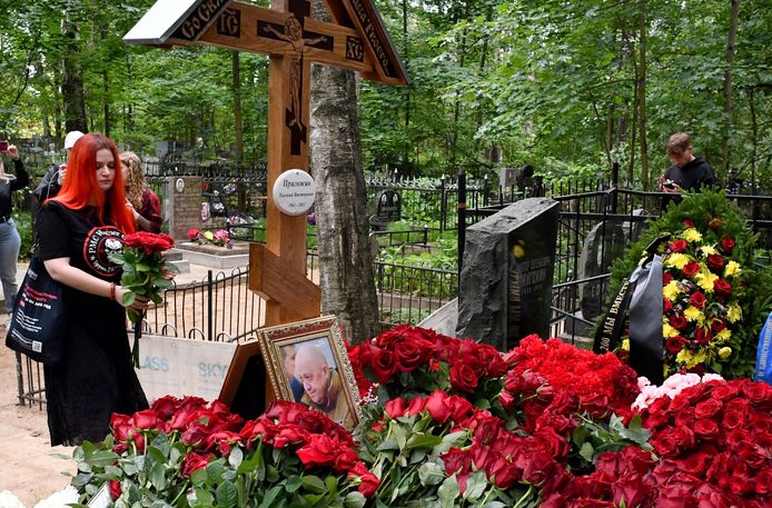 Une femme portant un t-shirt avec le logo du groupe PMC Wagner dépose des fleurs sur la tombe d'Evgueni Prigojine, le 30 août 2023.