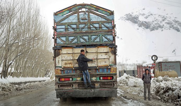 Een jongeman laat zich achter een vrachtwagen meevoeren naar Kabul, in Afghanistan. Foto Massoud Hossaini