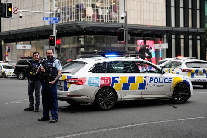 Gewapende politieagenten houden de wacht bij een afgezette straat in het centrum van Auckland.