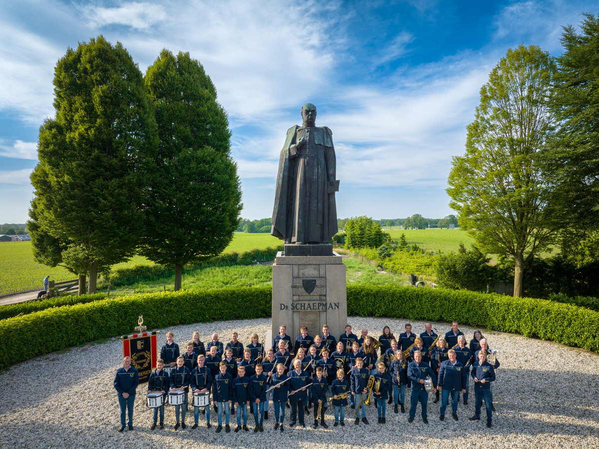 De leden van de Dr. Schaepmanharmonie poseren bij het beeld van Schaepman op de es in Tubbergen.
