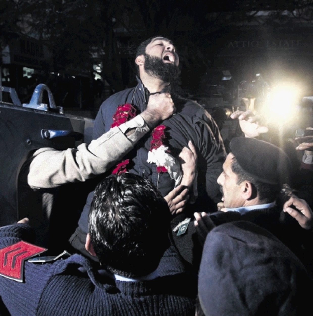 Lijfwacht Mumtaz Qadri roept religieuze teksten terwijl agenten in Islamabad hem wegvoeren. ( FOTO REUTERS ) Beeld REUTERS
