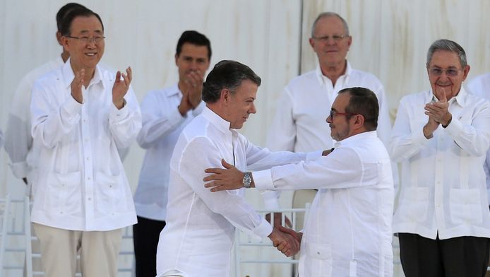 De Colombiaanse president en de leider van FARC schudden elkaar de hand na de ondertekening van het vredesakkoord.