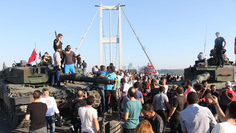Politieagenten en aanhangers van Erdogan bij de brug over de Bosporus in Istanbul. Beeld epa