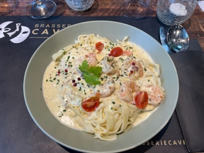 De tagliatelle met scampi in een pikante roomsaus.