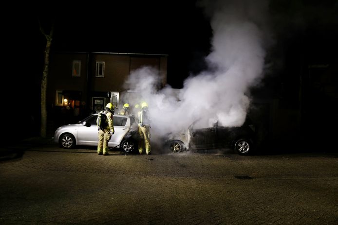 De brandweer blust twee brandende auto's aan de Spechtstraat in Gennep.