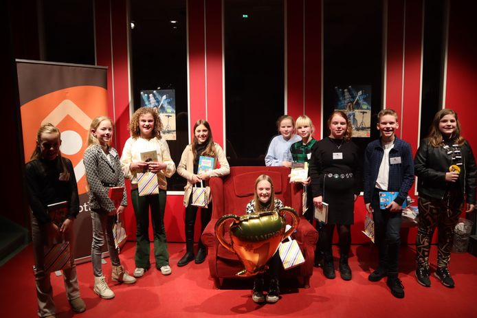 Kinderburgemeester Annemijn Snijders en de negen deelnemers aan de voorleeswedstrijd met in het midden de trotse kampioene Hanna Nijland van De Wiekslag.