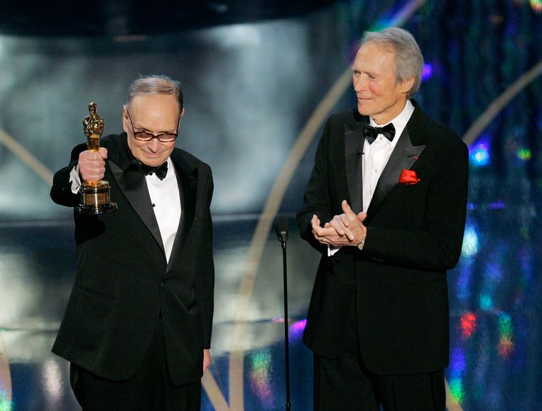 Componist Ennio Morricone ontvangt in 2007 uit handen van acteur en regisseur Clint Eastwood een ere-Oscar voor zijn legendarische filmmuziek.  Beeld AP Photo