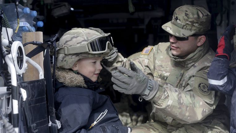 Een Amerikaanse soldaat en een jongetje uit Estland tijdens militaire oefening Dragoon Ride op 22 maart, bedoeld om steun van de NAVO aan oosterse lidstaten te onderstrepen. Beeld reuters