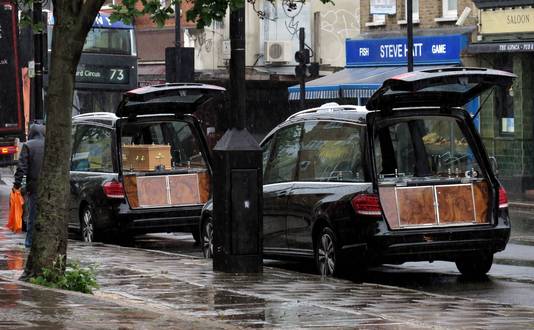 Twee lijkwagens met daarin COVID-19-overledenen in een Londense straat.