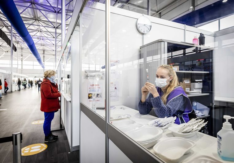 Medewerkers bereiden een vaccinatie van Pfizer voor op de vaccinatielocatie op luchthaven Schiphol.  Beeld ANP