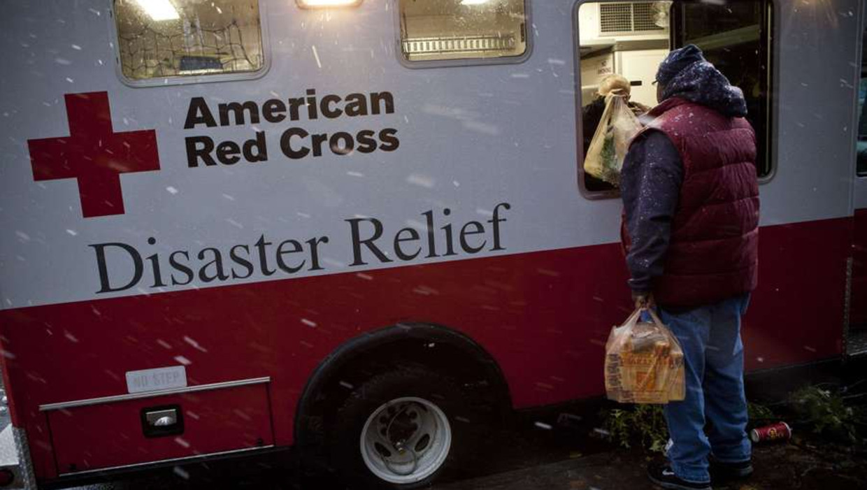 Slachtoffers krijgen voedselpakketen van het Rode Kruis. Beeld reuters