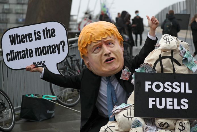 Un manifestante a Glasgow si era travestito da primo ministro Johnson e si chiedeva dove stessero andando i soldi per il cambiamento climatico.  I soldi a quanto pare esistono per i combustibili fossili.