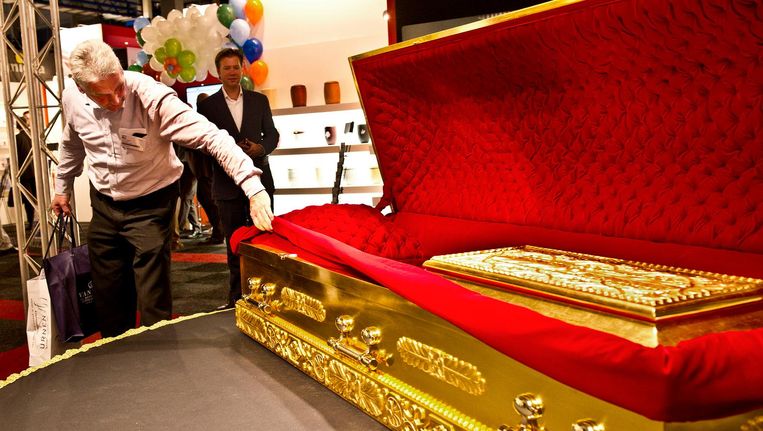 Een met goud belegde kist op de Uitvaart Vakbeurs in Gorinchem. Het is niet verplicht een overledene in een kist te begraven of te cremeren. Beeld anp