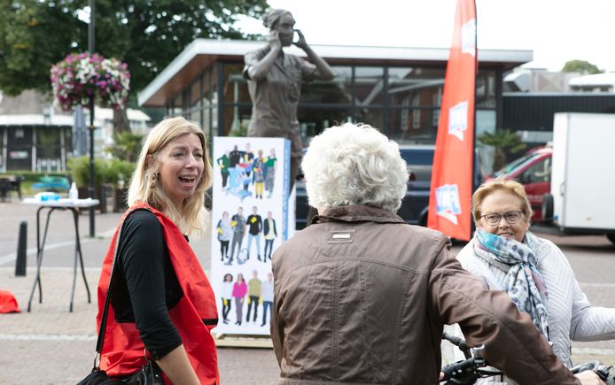 Anita Habermann van FNV spreekt passanten aan bij het grote standbeeld in Ommen.