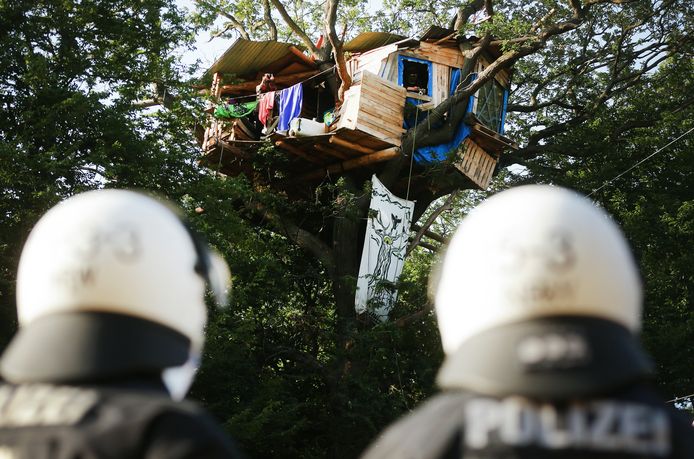 Foto del 2020. Due agenti di polizia tedeschi vicino a una casa sull'albero costruita da attivisti nella foresta di Hambach.