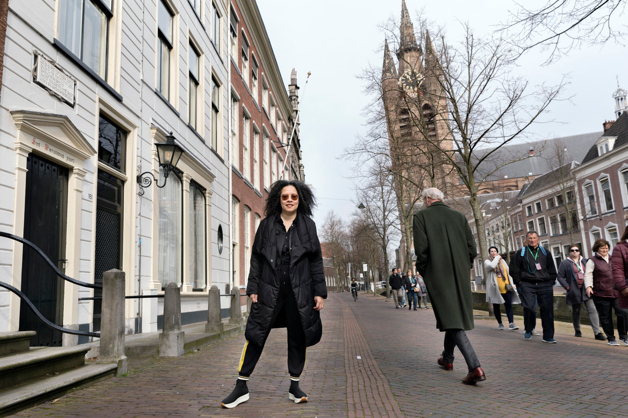 Auteur Nancy Jouwe aan de Oude Delft. In het witte pand links woonden de prinsen Kwasi en Kwame. Rechtsachter de Oude Kerk met het mausoleum van Piet Hein.  Beeld Inge Van Mill
