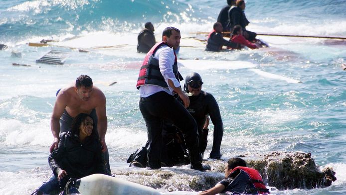 Reddingswerkers helpen een vluchtelingen uit het water op het Eiland Rhodos, in het zuidoosten van Griekenland