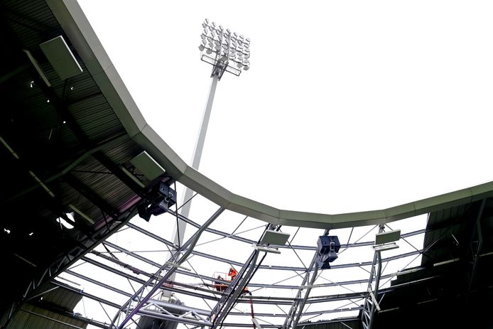 Medewerkers van de inspectie inventariseren vanuit een hoogwerker de schade die aan het stadion van ADO Den Haag is ontstaan door storm Eunice.