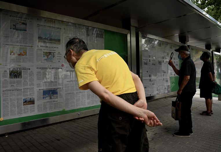 Mensen in Peking lezen krantenartikels over China's militaire oefeningen rond Taiwan. Beeld AFP