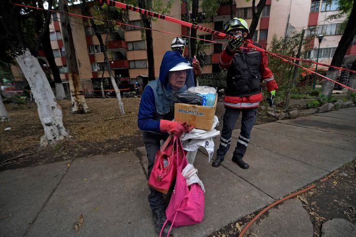A resident recovers his belongings from an apartment building affected by a quake in Mexico City on June 24, 2020, amid the new coronavirus pandemic. - A 7.4 magnitude earthquake struck southern Mexico on Tuesday, killing six people, sending hundreds fleeing from their homes and forcing the closure of a major state-owned oil refinery. (Photo by PEDRO PARDO / AFP)