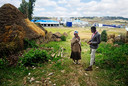 Manager bij de Habesha-bierbrouwerij in Ethiopië Biruk Assegid (l) in gesprek met een van de omwonenden,  Atsede Feke. Op de achtergrond de brouwerij.