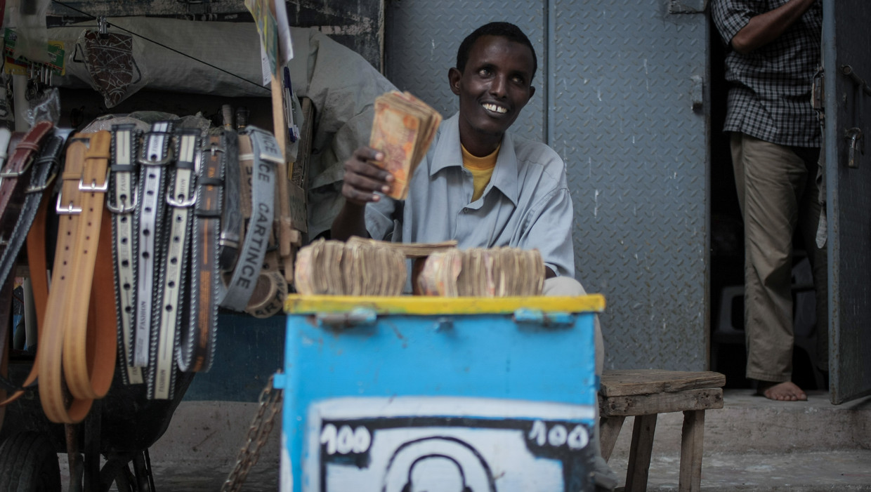Een geldwisselaar in de Somalische hoofdstad Mogadishu betaalt familieleden de overmakingen van arbeidsmigranten in het Westen. Beeld afp