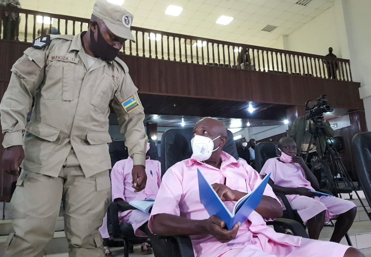 Paul Rusesabagina, met medeverdachten en een bewaker naast zich in de rechtszaal vorige week in Rwanda.  Beeld Reuters