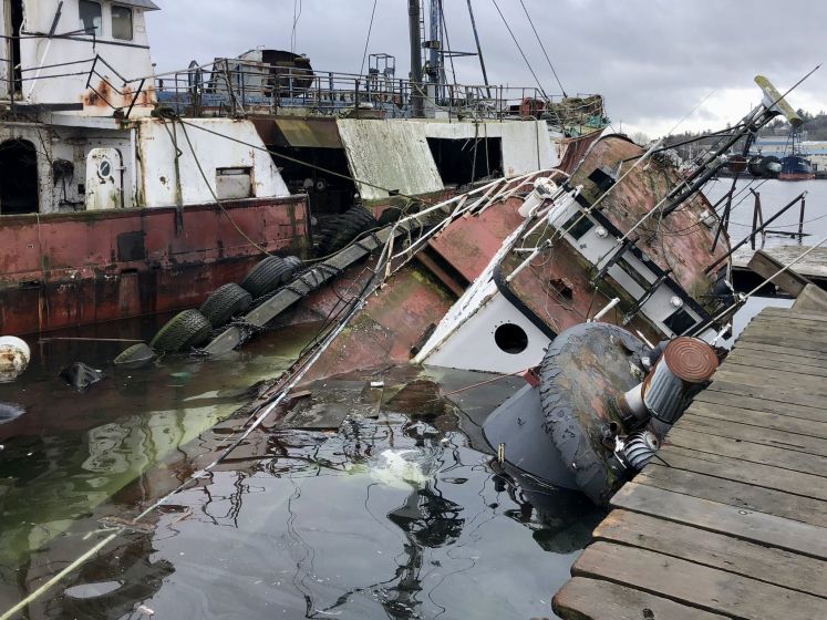 Vervallen sleepboot zinkt in haven van Seattle