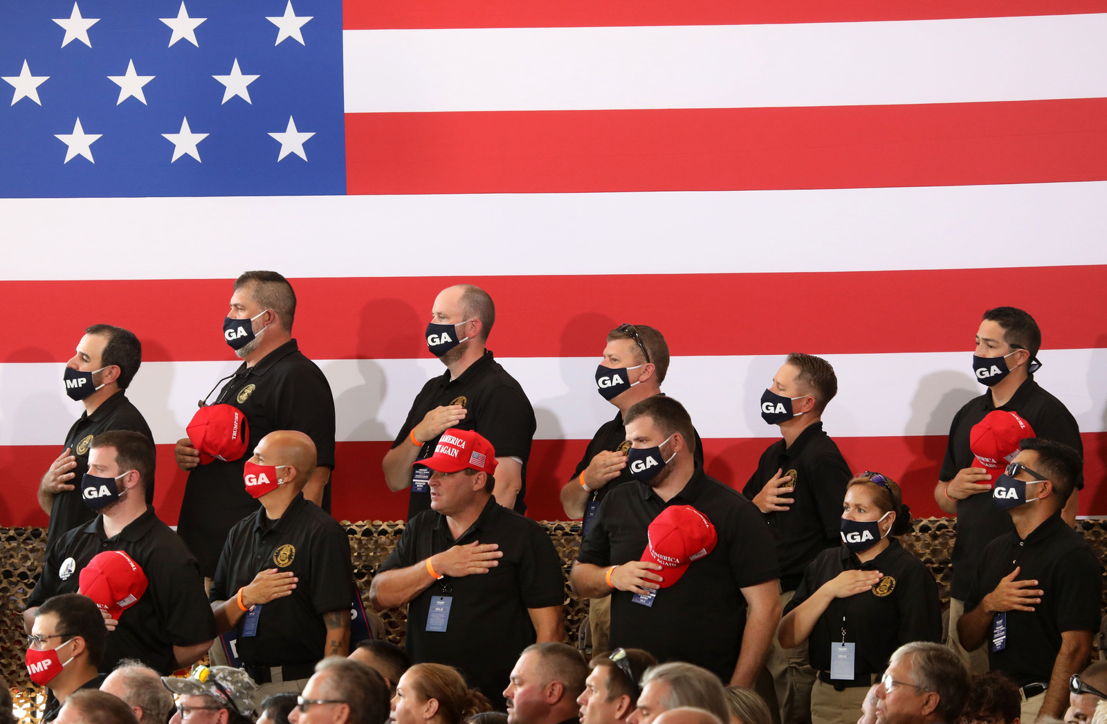 Trump-aanhangers zingen dinsdag patriottisch het Amerikaanse volkslied in Arizona, op dezelfde dag dat een Senaatscommissie concludeerde dat Trumps campagneteam in 2016 uitgebreid contact had met Rusland in een poging om de presidentsverkiezingen te winnen.  Beeld Getty Images