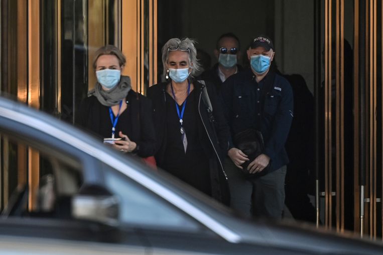 Marion Koopmans, Peter Daszak en andere onderzoekers van het WHO-team vrijdag bij de uitgang van het Hilton Wuhan Optics Valley Hotel waar ze verblijven. Beeld AFP