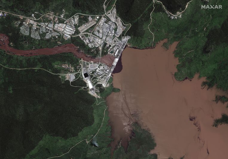 Op de satellietfoto van deze week is te zien hoe het water van de Blauwe Nijl in het stuwmeer (rechts) achter de Grote Renaissancedam in Ethiopië stroomt. Links op de foto verlaat een deel van het Nijlwater de dam en stroomt richting Soedan en Egypte.  Beeld EPA
