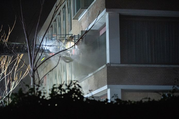 De brandweer probeert met een hoogwerker de brand te bestrijden
