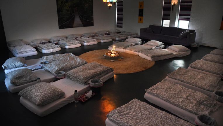 De bedden voor een ayahuascaceremonie bij Om-Mij ergens in de Achterhoek, met ernaast steeds een emmer: veel deelnemers moeten overgeven van de tripthee. Beeld Marcel van den Bergh / de Volkskrant