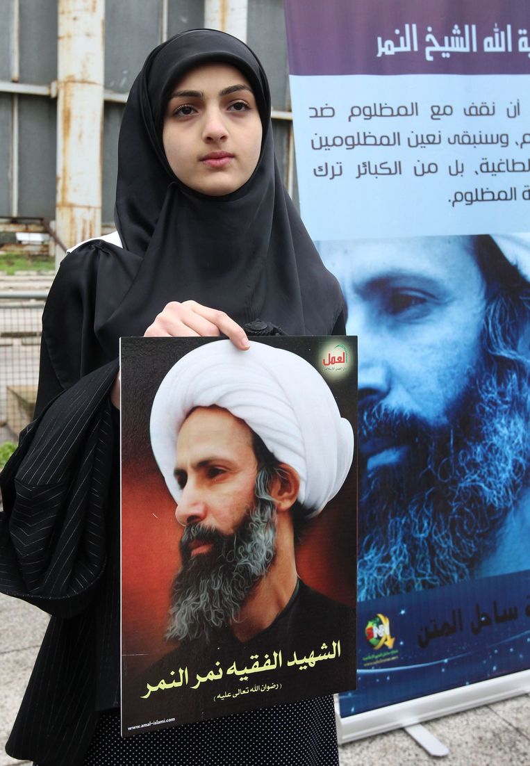Een vrouw houdt een portret van de geestelijke Nimr al-Nimr vast. Beeld anp