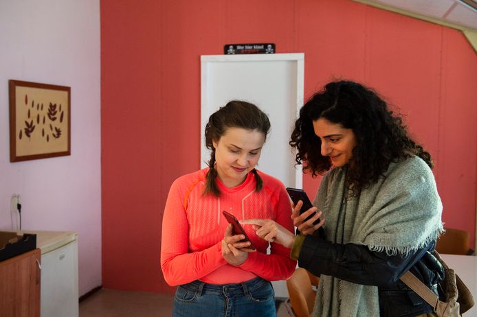 FNV'er Ellen Demirdag (r) wisselt op Haarendael gegevens uit met Sara, een arbeidsmigrante uit Slowakije.